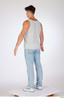 Darren a-poses blue jeans casual dressed grey tank top standing…